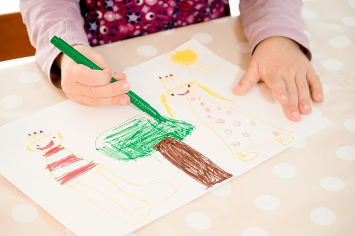 Child drawing a picture of a king and queen