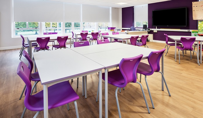 empty classroom with tables with purple chairs